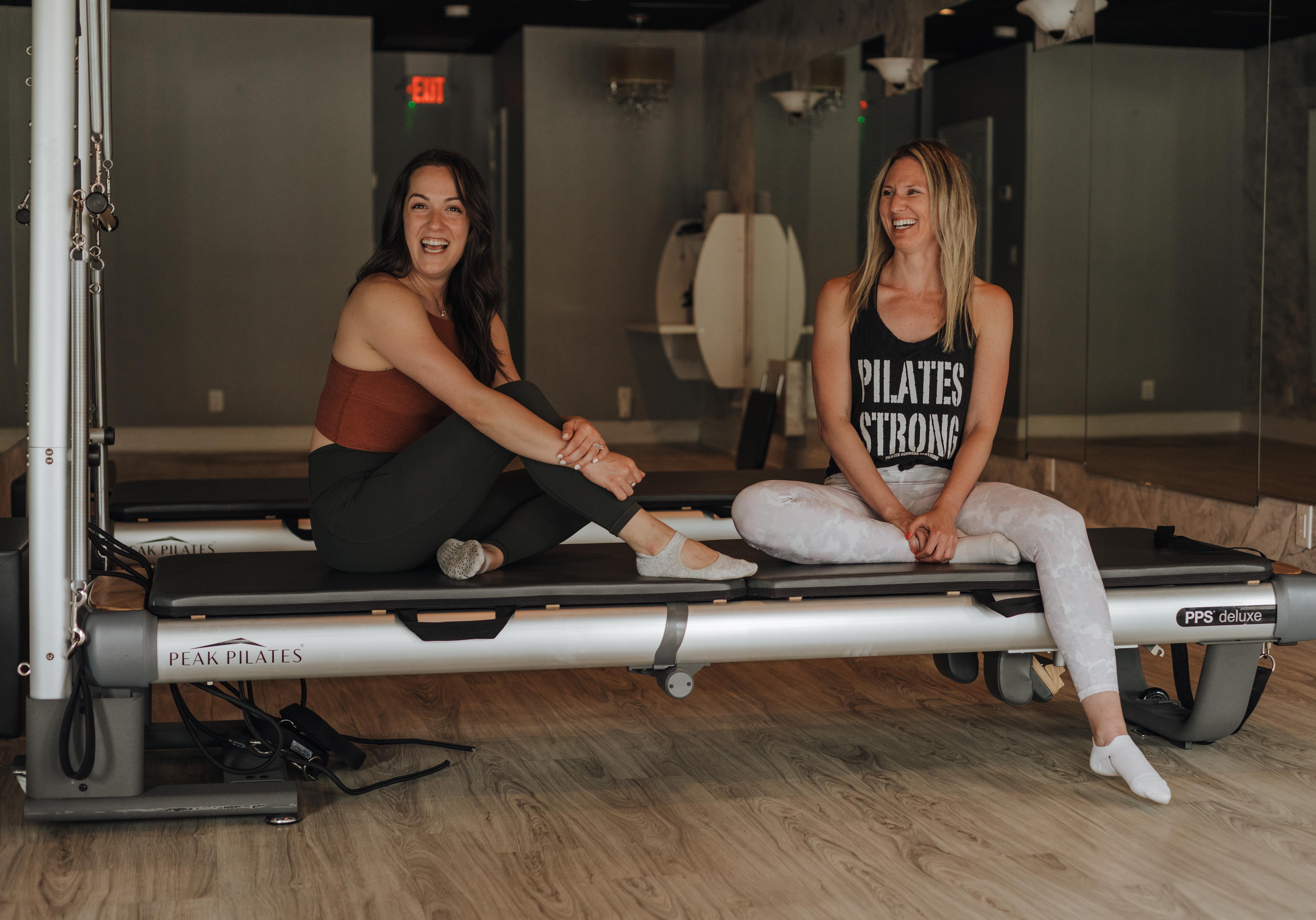 Two members on a Peak Pilates reformer at CS Fit Pilates